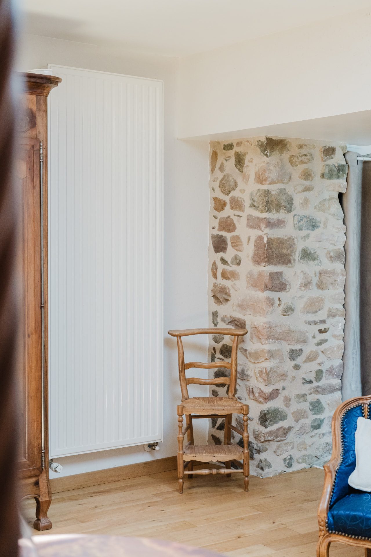 Mur de pierre apparente et fauteuil paillé ancien dans la Chambre Confort